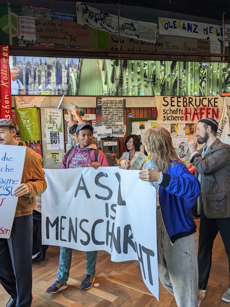 Eine Gruppe Menschen mit Transparenten in der Hand.